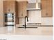 Close-up of the kitchen island featuring quartz countertops, sleek black faucet and stainless steel stove at 1350 E Prescott St, Gilbert, AZ 85298