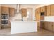 Modern kitchen boasts stainless steel appliances, an island with a white countertop and wooden cabinets at 1350 E Prescott St, Gilbert, AZ 85298