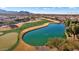 Aerial view of a golf course community with lake and mountain views at 26573 W Abraham Ln, Buckeye, AZ 85396