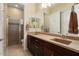 Double vanity bathroom with dark wood cabinets and a shower at 26573 W Abraham Ln, Buckeye, AZ 85396