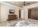Main bedroom with barn door, TV, and large dresser at 26573 W Abraham Ln, Buckeye, AZ 85396