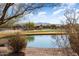 Luxury homes surround a serene pond and golf course, with mountain views in the background at 26573 W Abraham Ln, Buckeye, AZ 85396