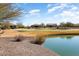 Golf course and pond view of community, showcasing multiple luxury homes at 26573 W Abraham Ln, Buckeye, AZ 85396