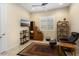 Home office with built-in shelving, comfortable chair, and large TV at 26573 W Abraham Ln, Buckeye, AZ 85396