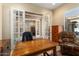 Home office with wood desk, comfortable chair, and built-in shelving at 26573 W Abraham Ln, Buckeye, AZ 85396