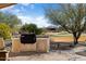 Built-in outdoor kitchen with grill and stone counters at 26573 W Abraham Ln, Buckeye, AZ 85396