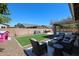 Inviting backyard featuring a pool, covered patio, artificial turf, and outdoor seating at 6352 W Campo Bello Dr, Glendale, AZ 85308