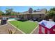 Charming backyard featuring artificial turf, a patio with seating, and a playhouse at 6352 W Campo Bello Dr, Glendale, AZ 85308