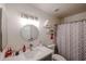 Bright bathroom featuring a round mirror and shower with a patterned curtain at 6352 W Campo Bello Dr, Glendale, AZ 85308