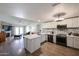 Open kitchen with stainless steel appliances, light gray cabinets, a spacious island, and views into the living room at 6352 W Campo Bello Dr, Glendale, AZ 85308