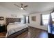 Bright main bedroom featuring a ceiling fan, large bed, and ample natural light from the windows at 6352 W Campo Bello Dr, Glendale, AZ 85308