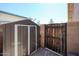 Side yard features a storage shed and a wood gate in a fenced area at 6352 W Campo Bello Dr, Glendale, AZ 85308