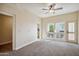Spacious carpeted bedroom featuring a ceiling fan and an abundance of natural light at 6411 S River Dr # 10, Tempe, AZ 85283