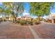 Picturesque view of a landscaped roundabout with mature trees leading to elegant homes in a peaceful desert community at 6411 S River Dr # 10, Tempe, AZ 85283