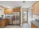 Bright kitchen boasts stainless steel appliances, wood cabinets and a back door at 6411 S River Dr # 10, Tempe, AZ 85283