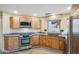 Well-lit kitchen features modern stainless steel appliances, natural wood cabinetry and gray countertops at 6411 S River Dr # 10, Tempe, AZ 85283