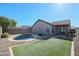 Inviting kidney-shaped pool with grassy area and fire pit at 10778 W Cambridge Ave, Avondale, AZ 85392