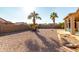 Gravel backyard with palm trees and a patio at 11623 W Lemon Ct, Surprise, AZ 85378