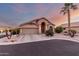 Tan house with a two-car garage and palm trees at 11623 W Lemon Ct, Surprise, AZ 85378
