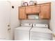 Functional laundry room with washer, dryer, and cabinets at 11623 W Lemon Ct, Surprise, AZ 85378