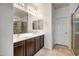 Double vanity bathroom with dark brown cabinets and a large mirror at 13257 W Avenida Del Rey Dr, Peoria, AZ 85383