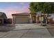 House exterior featuring a two-car garage and basketball hoop at 13257 W Avenida Del Rey Dr, Peoria, AZ 85383