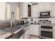 Kitchen features stainless steel sink, granite countertops, and tin backsplash at 18147 W Desert View Ln, Goodyear, AZ 85338