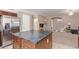 Kitchen island with dark countertop and stainless steel fridge at 18239 N Cook Dr, Maricopa, AZ 85138
