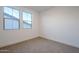 Well-lit bedroom with neutral carpeting and two large windows at 21290 E Sparrow Dr, Queen Creek, AZ 85142