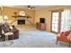 Comfortable living room with fireplace, modern TV, warm lighting, and access to outdoor patio at 2664 W Ocaso Cir, Mesa, AZ 85202