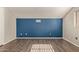 Bright bedroom featuring dark wood floors and blue accent wall at 4901 S Calle Los Cerros Dr # 241, Tempe, AZ 85282