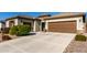Two-car garage with long driveway and desert landscaping at 5640 W Victory Way, Florence, AZ 85132
