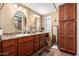 Double vanity bathroom with updated wood cabinets and flooring at 6209 E Mckellips Rd # 446, Mesa, AZ 85215