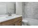 Updated bathroom with marble tile shower and modern vanity at 6934 W Mclellan Rd, Glendale, AZ 85303