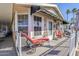 Mobile home exterior showcasing a covered porch with red chaise lounge at 8865 E Baseline Rd # 1106, Mesa, AZ 85209
