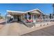 Mobile home with carport, covered porch and red patio furniture at 8865 E Baseline Rd # 1106, Mesa, AZ 85209