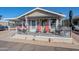 Front view of a beige mobile home with a covered porch and red chairs at 8865 E Baseline Rd # 1106, Mesa, AZ 85209