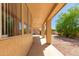 A covered patio showing tan columns and landscaping elements visible from the tan-colored window frames at 10417 E Champagne Dr, Sun Lakes, AZ 85248