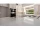 Open kitchen with stainless steel appliances, white cabinets, and quartz countertops offers space for cooking at 10417 E Champagne Dr, Sun Lakes, AZ 85248