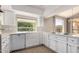 Bright kitchen features white cabinets, stainless steel appliances, and a window overlooking lush greenery at 10417 E Champagne Dr, Sun Lakes, AZ 85248