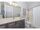 Guest bathroom with a tub shower combo and dark cabinets at 12128 W Desert Mirage Dr, Peoria, AZ 85383