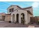 Two-story house with tan exterior, arched entryway, and a two-car garage at 12149 W Desert Moon Way, Peoria, AZ 85383