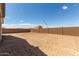 A large backyard with dirt and a brick wall under a clear, blue sky at 12358 W Marguerite Ave, Avondale, AZ 85323