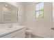 A bright bathroom features white vanity and window overlooking the shower at 12358 W Marguerite Ave, Avondale, AZ 85323