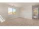 Empty bedroom with new carpet, a window, and an open doorway to a bathroom at 12358 W Marguerite Ave, Avondale, AZ 85323