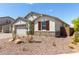Charming single-story home featuring stone accents, a two-car garage, and low-maintenance desert landscaping under a bright blue sky at 12358 W Marguerite Ave, Avondale, AZ 85323