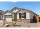 Charming home exterior with stone accents, low water landscaping, and light gray paint at 12358 W Marguerite Ave, Avondale, AZ 85323