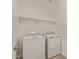 A well-lit laundry room with modern washer, dryer, and shelving at 12358 W Marguerite Ave, Avondale, AZ 85323