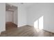 Well-lit bedroom with wood-look tile floors and hallway access at 13528 W Phacelia Ln, Peoria, AZ 85383