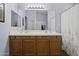 Bathroom with double sinks, wood cabinets, and a large mirror at 20948 N Sansom Dr, Maricopa, AZ 85138